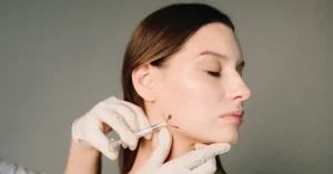 A women getting jaw corrections with fillers.